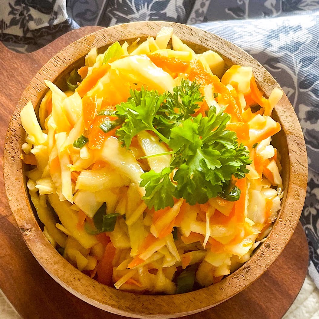 Traditional Russian coleslaw salad with spring onions in wooden bowl