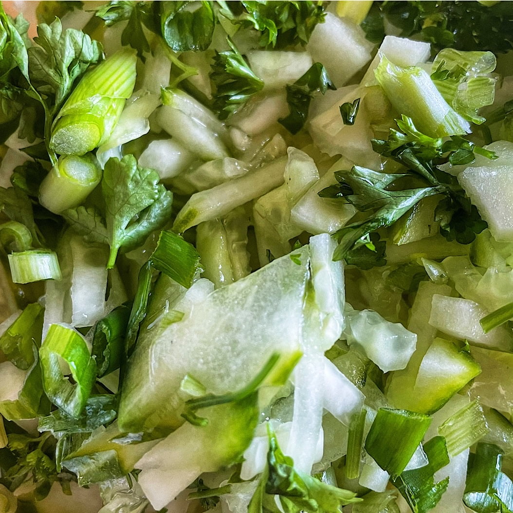 Close-up of Russian green cabbage salad with cucumber and fresh parsley