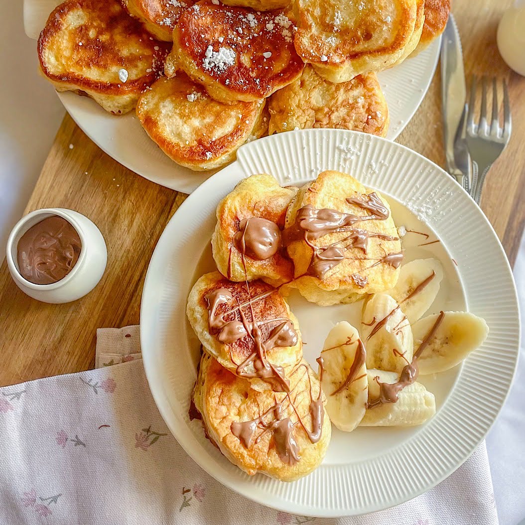 Homemade oladi pancakes — Russian kefir pancakes plated two ways with chocolate and icing sugar