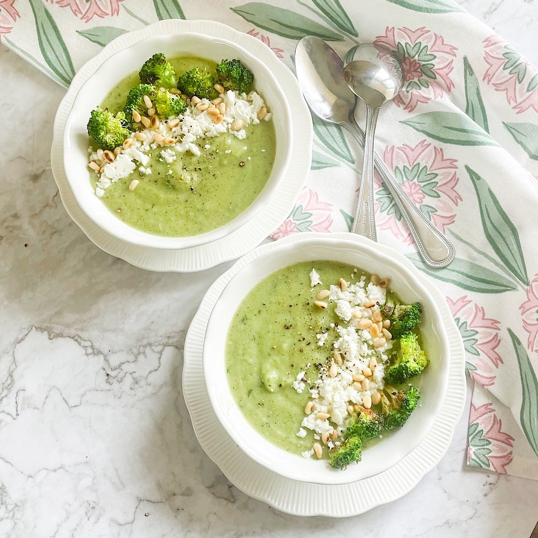 Overhead bowls of vibrant green broccoli feta soup with seared florets