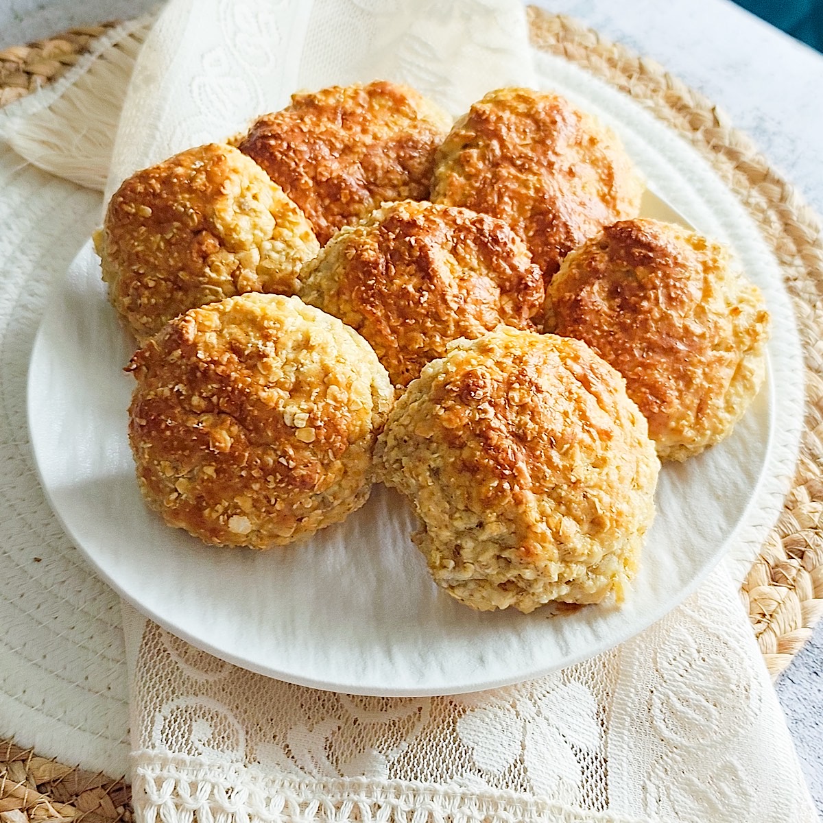 Golden baked cottage cheese cookies on a white plate with linen napkin