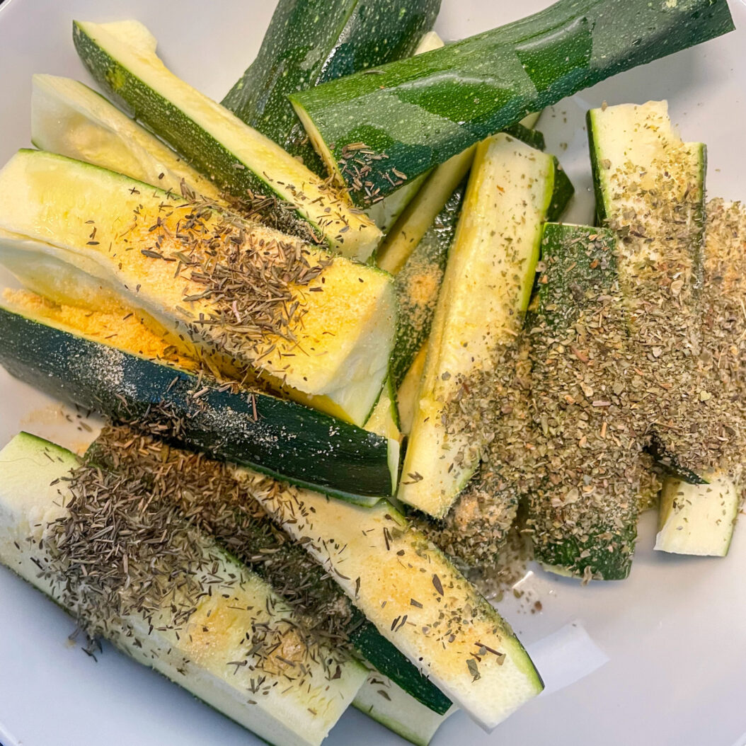 Courgette spears tossed with garlic powder, thyme and oregano for roasted courgette recipe