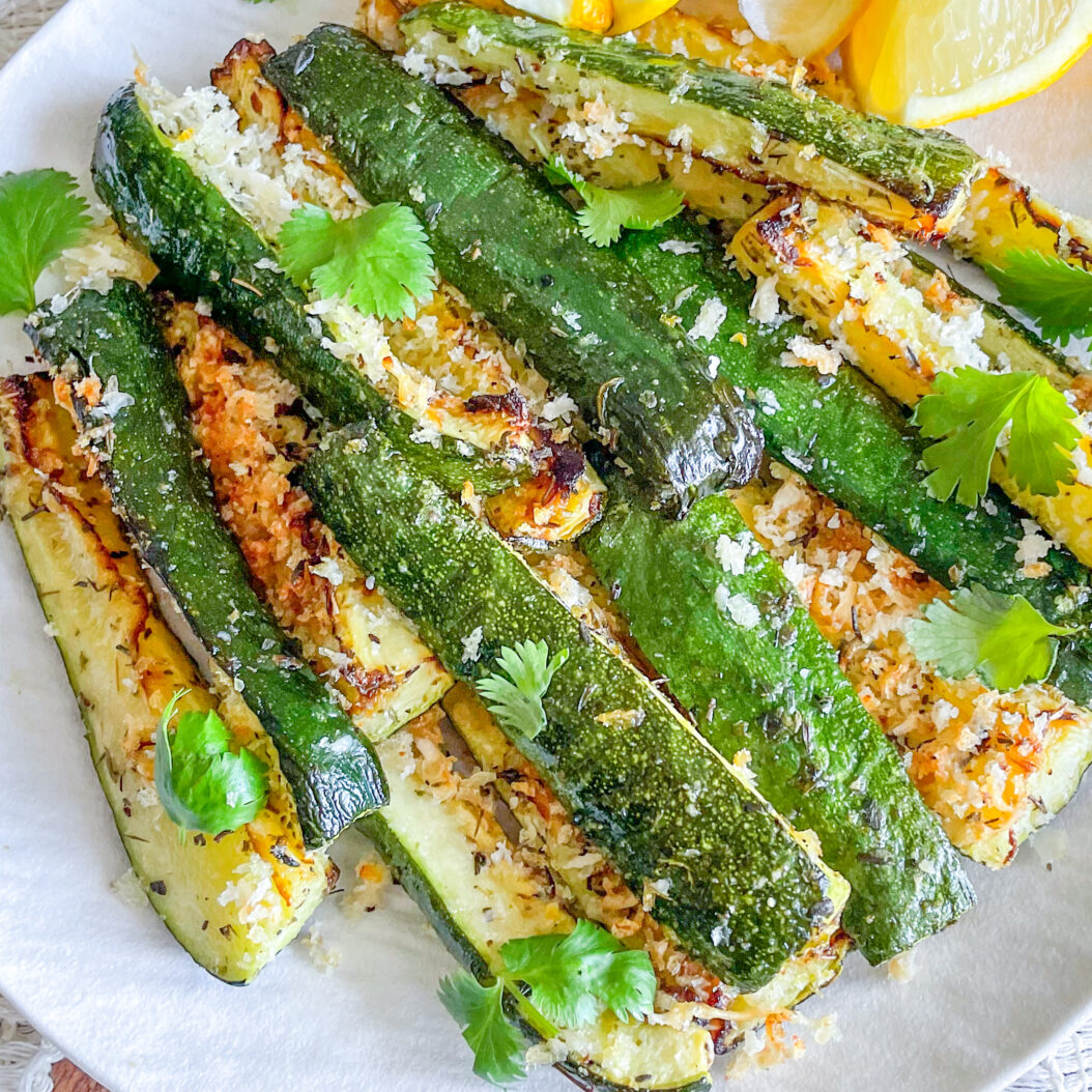 Close-up of crispy roasted courgette spears with golden parmesan breadcrumb topping