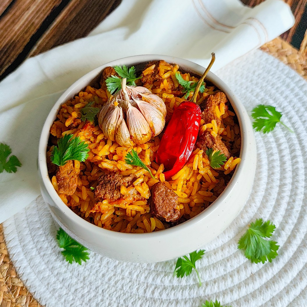 Uzbek-style beef plov served with chilli and whole garlic bulb