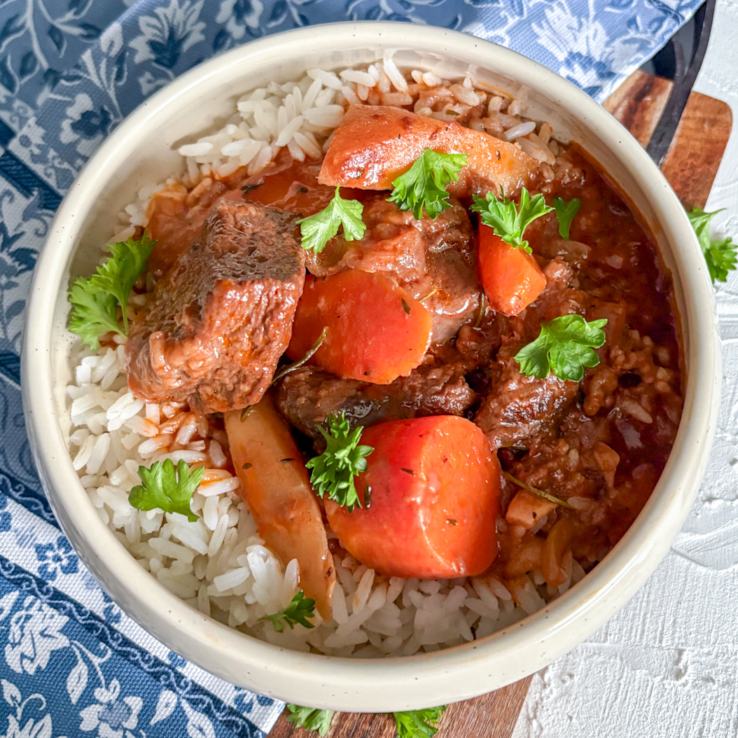 Hearty beef stew with carrots and parsnips in rich sauce, served on rice