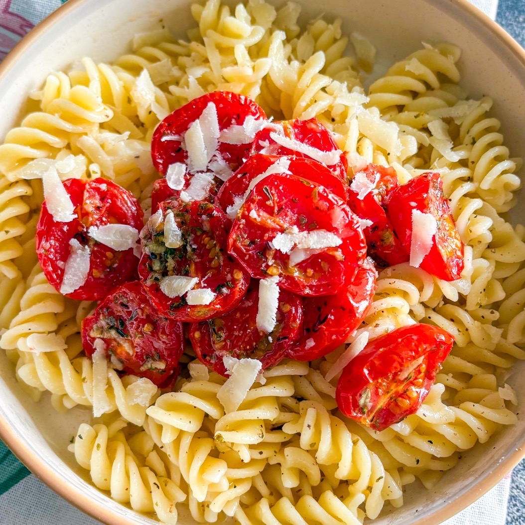 Roasted cherry tomatoes served over fusilli pasta with olive oil, herbs, and shaved Parmesan cheese.