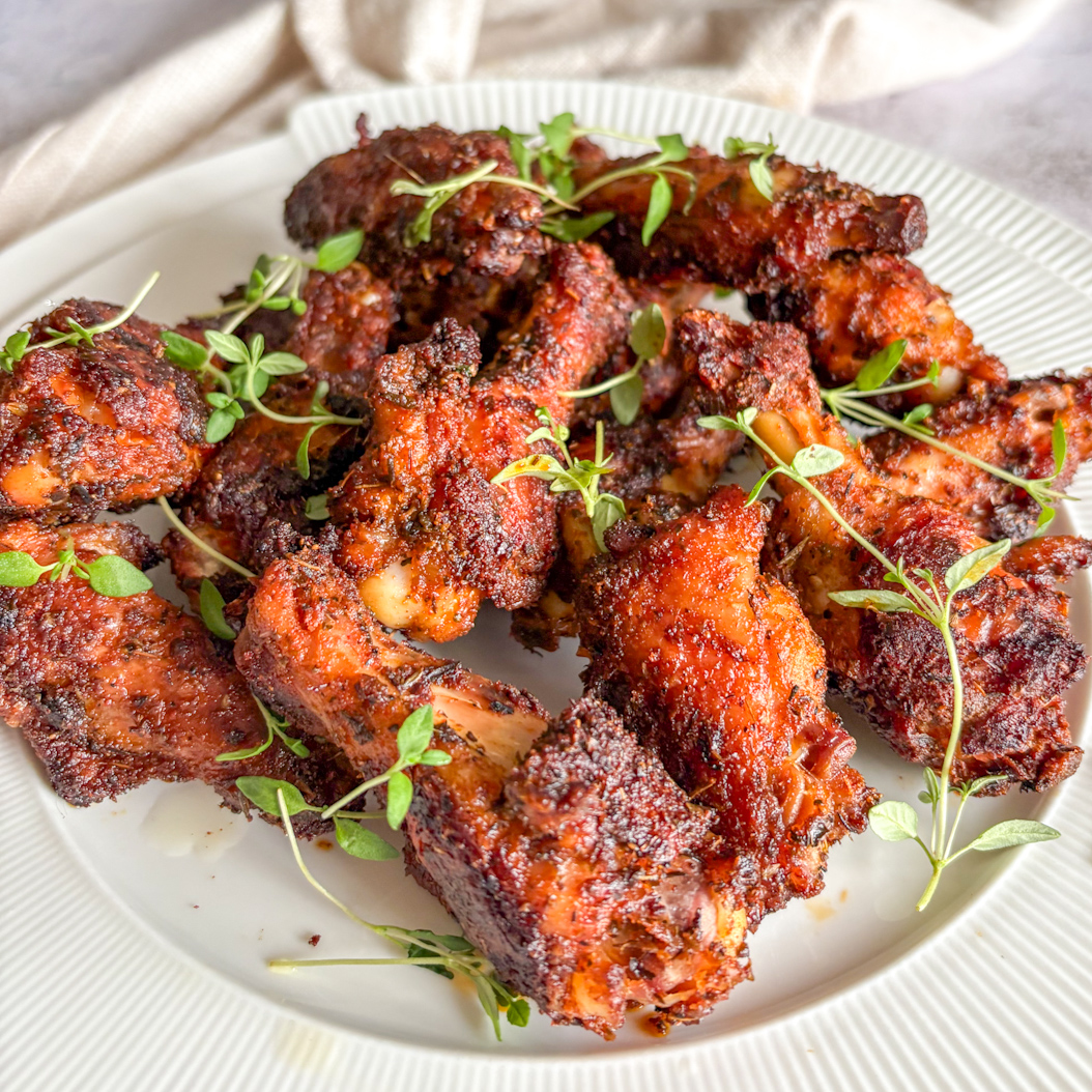 Plated Creole Chicken Wings with deep seasoning and fresh herb garnish.