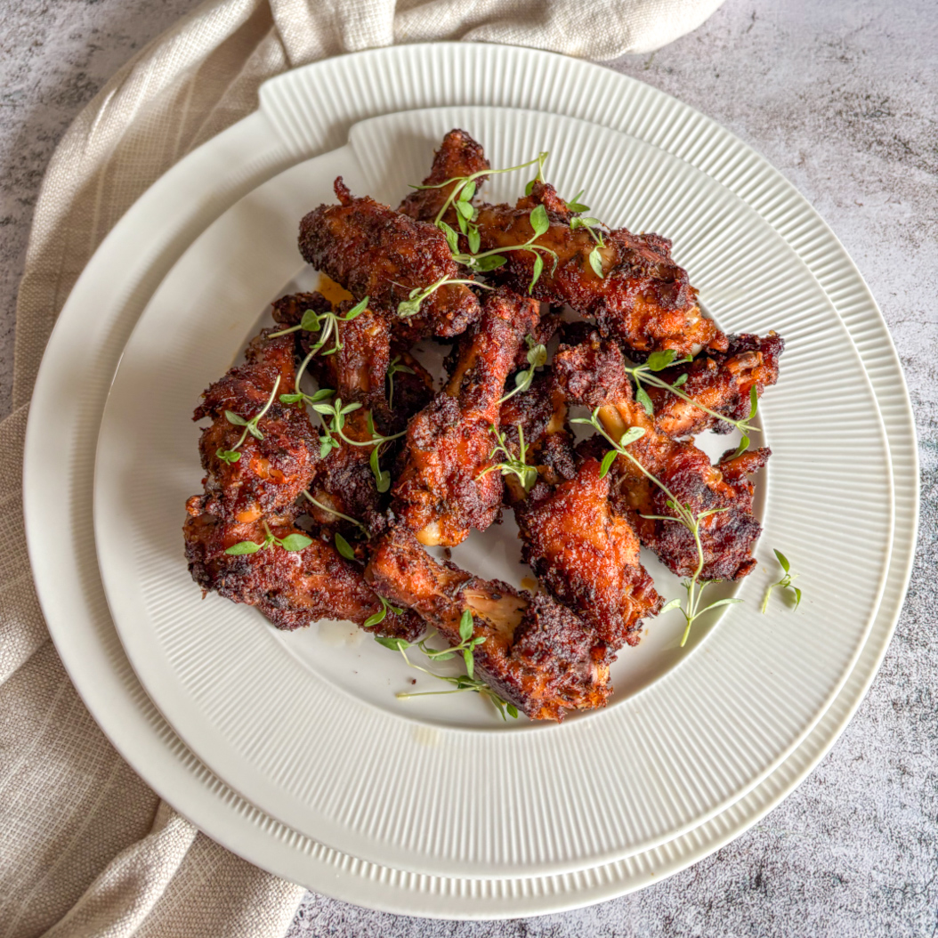Top view of Creole Chicken Wings arranged on a white plate, ready to serve.
