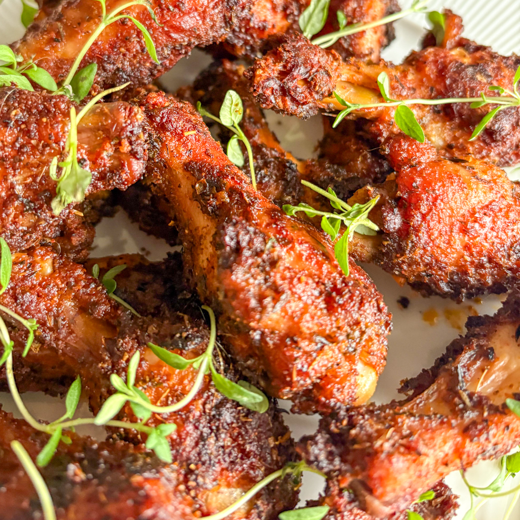 Close‑up of spicy, oven‑baked Creole Chicken Wings with crispy skin and herbs.