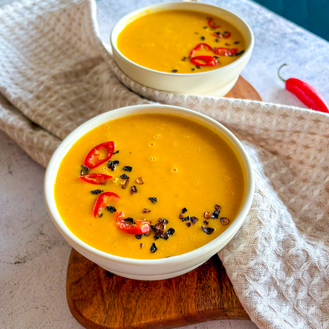 Homemade Sweet Potato and Carrot Soup with fresh chilli and spices, smooth and velvety texture