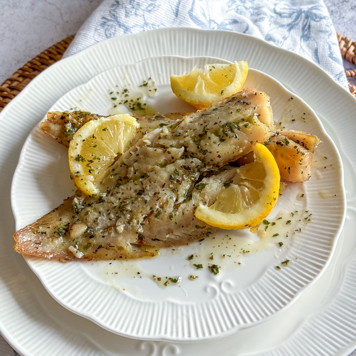 Close-up of baked pollock with lemon garlic butter sauce and herbs, flaky and tender