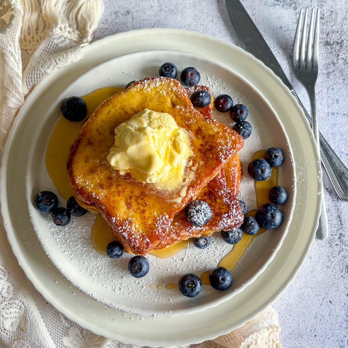 Top-down view of thick-cut Brioche French Toast surrounded by fresh berries, offering perfect Sunday brunch French toast ideas.