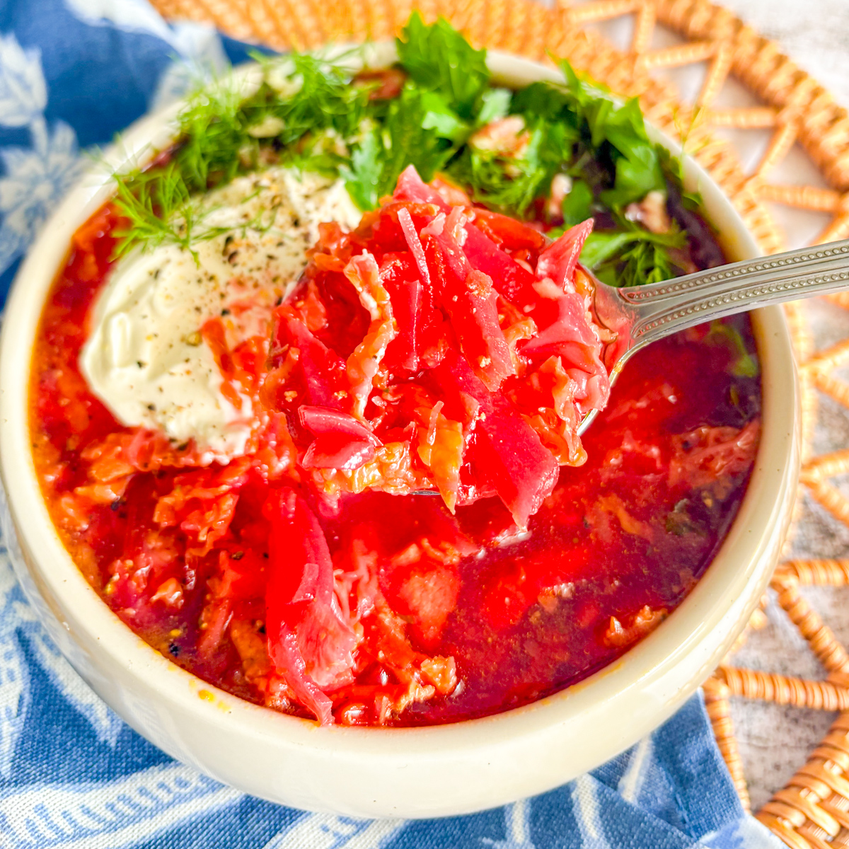 A close-up spoonful of chunky Chicken Borscht showing the texture of julienned beets and shredded chicken meat.