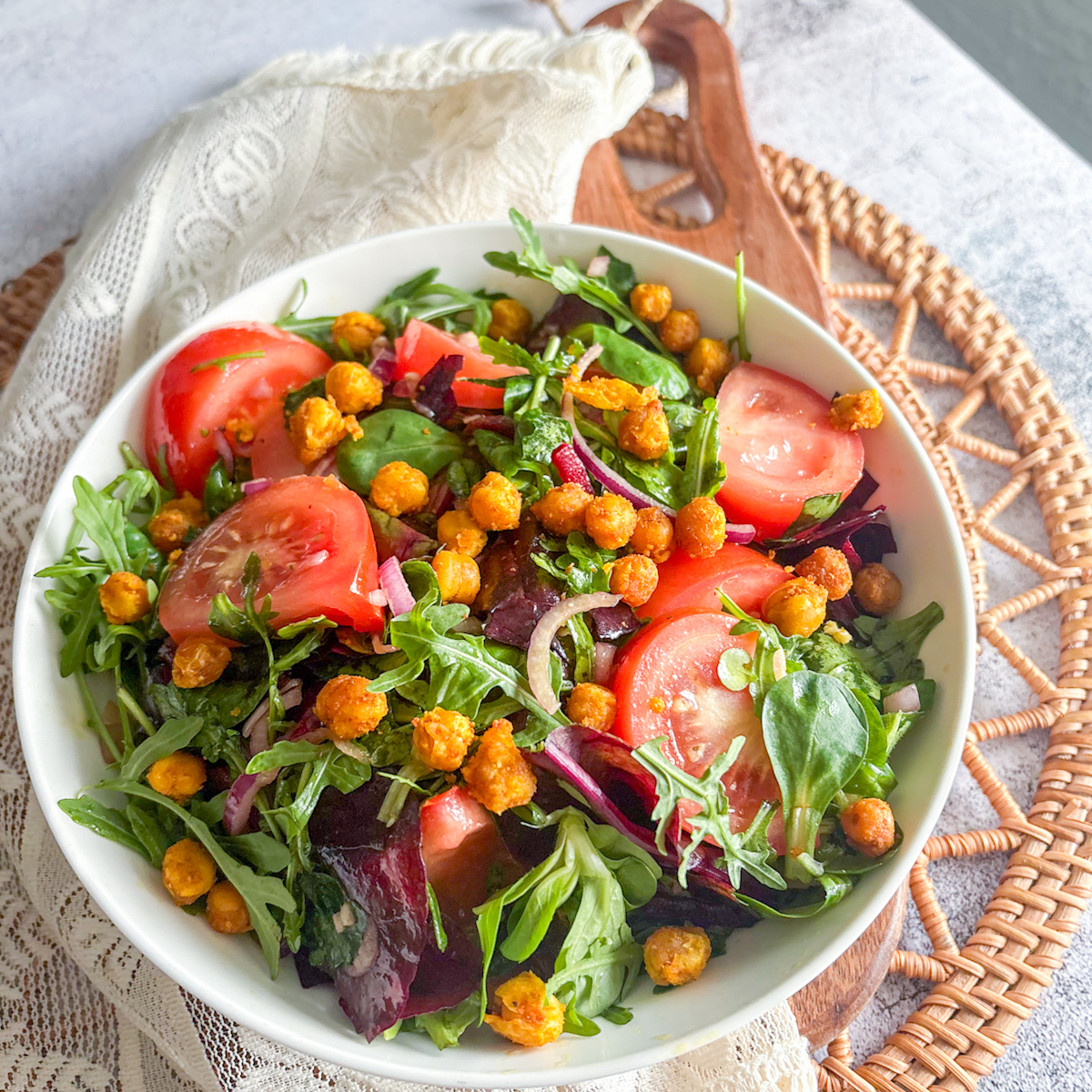 Bright and fresh fried chickpea salad with juicy tomato wedges and mixed leafy greens.