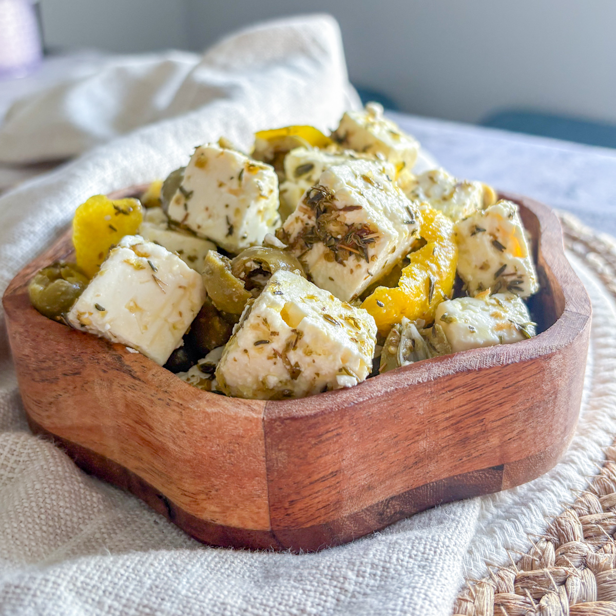 Marinated feta and green olives recipe in rustic wooden bowl