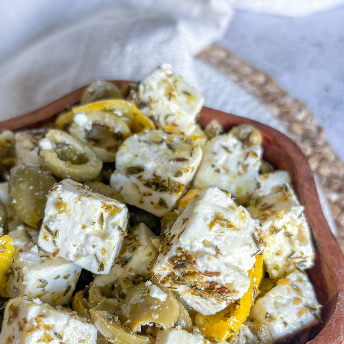 Close-up of marinated olives and feta cheese in wooden bowl