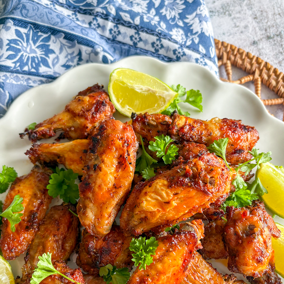 Crispy pantry staples chicken wings close-up with fresh lime wedges and parsley garnish.