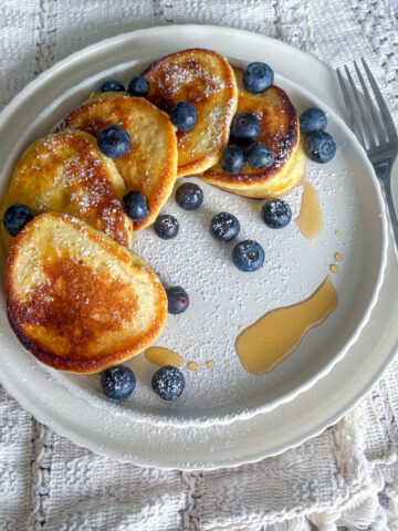 Healthy breakfast ricotta pancakes featuring a pillowy texture and a zesty and bright lemon flavour profile.