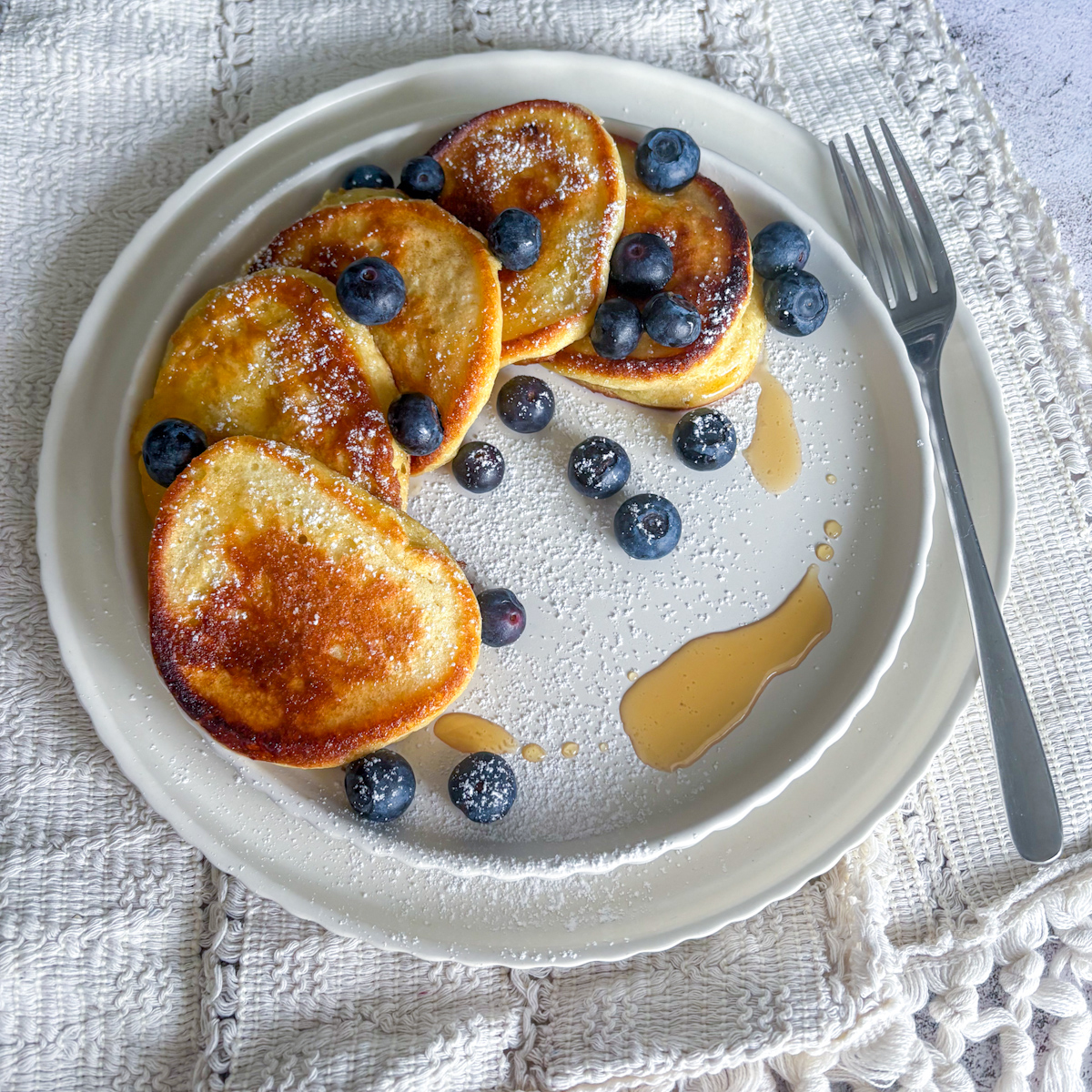 Healthy breakfast ricotta pancakes featuring a pillowy texture and a zesty and bright lemon flavour profile.