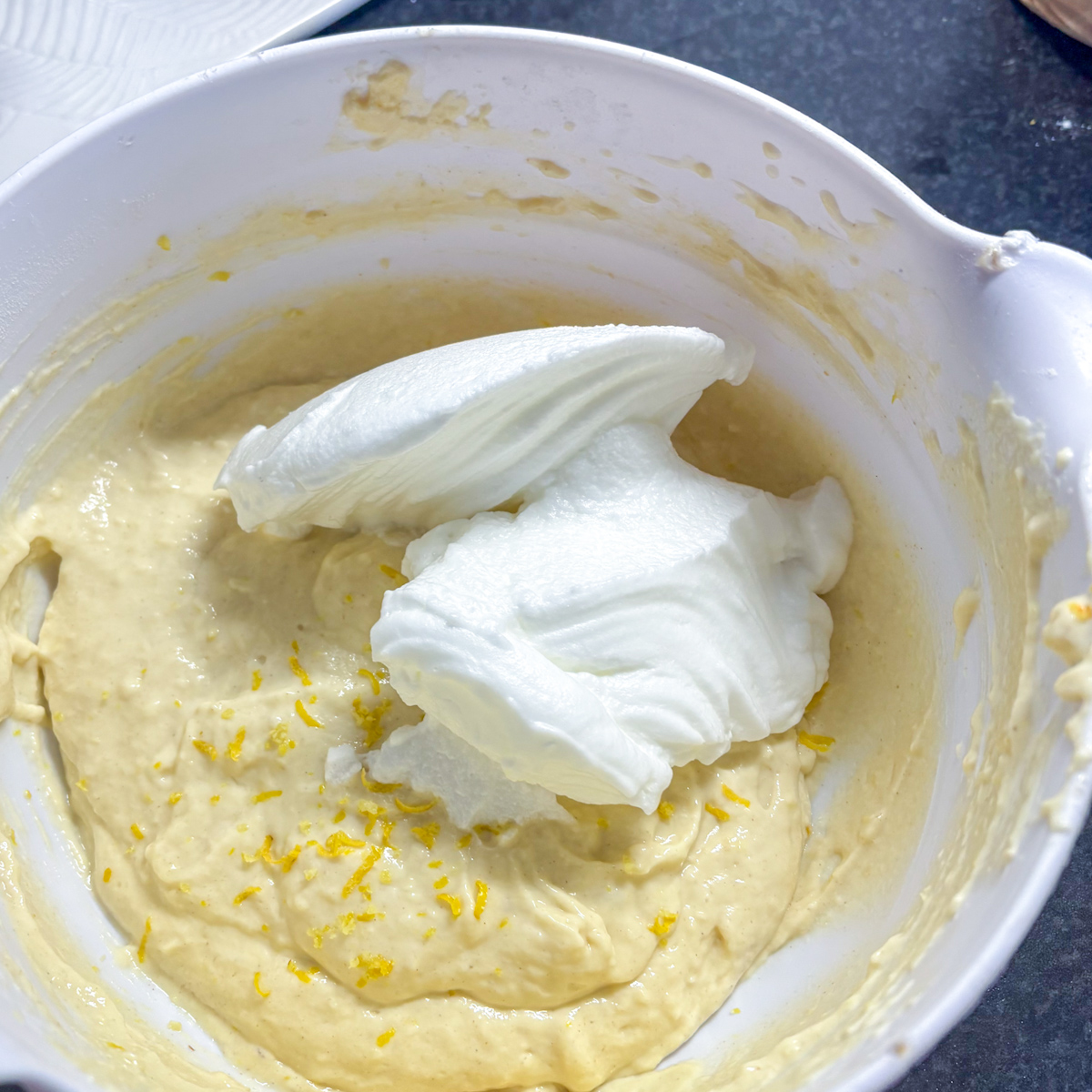 Gently folding the whisked egg whites into the lemon ricotta pancake batter.