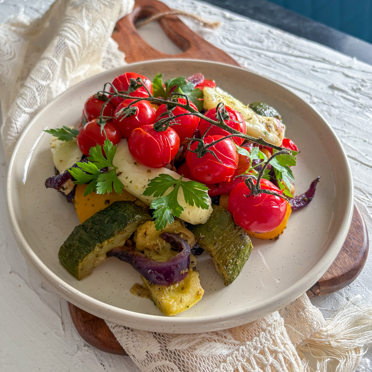 A healthy vegetarian dinner of roasted vegetables and halloumi, beautifully garnished with fresh parsley.