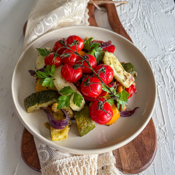 A healthy vegetarian dinner of roasted vegetables and halloumi, beautifully garnished with fresh parsley.