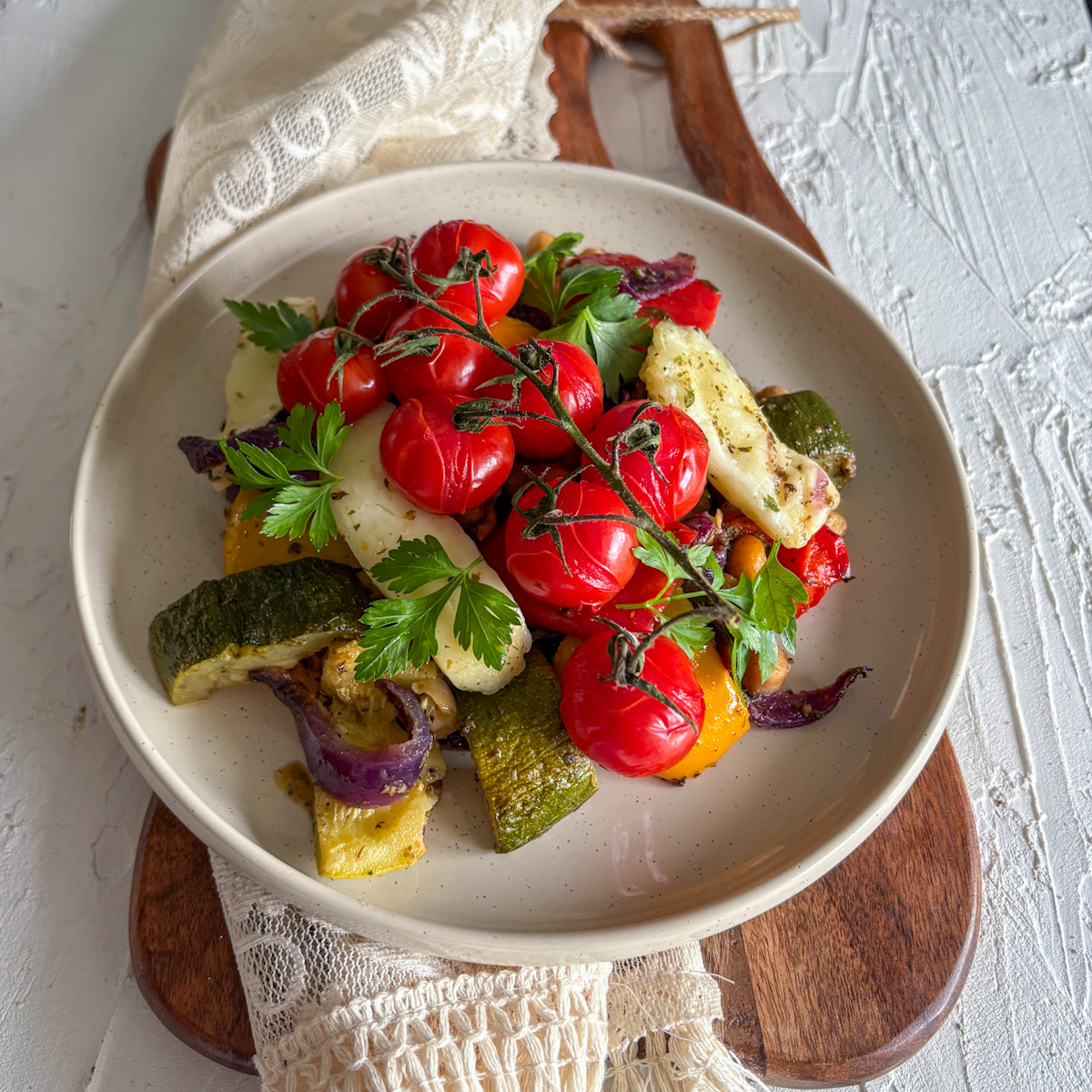 A healthy vegetarian dinner of roasted vegetables and halloumi, beautifully garnished with fresh parsley.