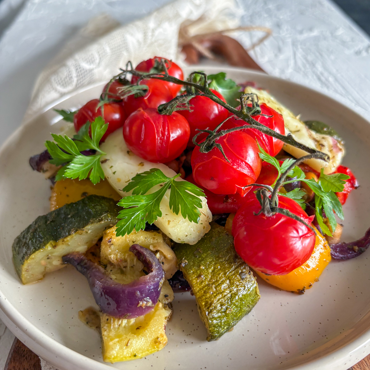 Vibrant roasted vegetables and halloumi cheese served on a rustic plate for a quick midweek meal.