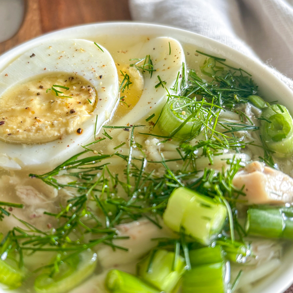 Close-up of Russian chicken soup with hard boiled egg and fresh dill
