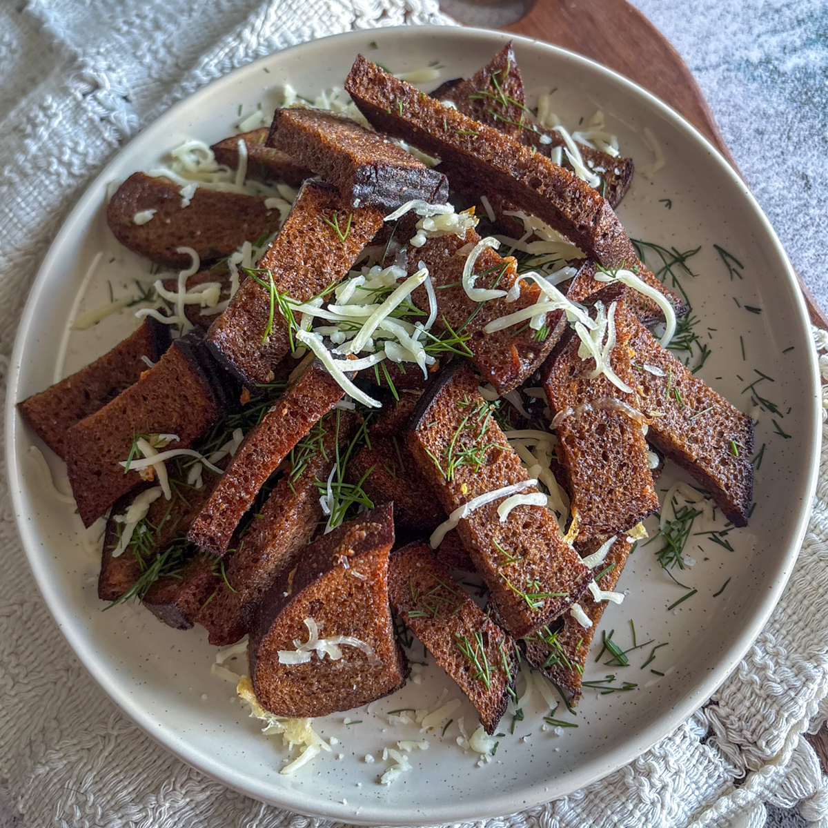 A full serving of Rye bread grenki strips piled high on a plate, ready to be eaten.