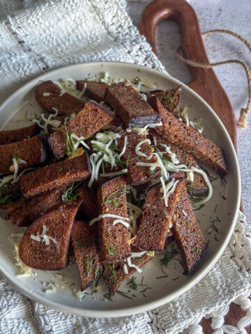 Traditional garlic rye bread snacks for beer served on a rustic plate with