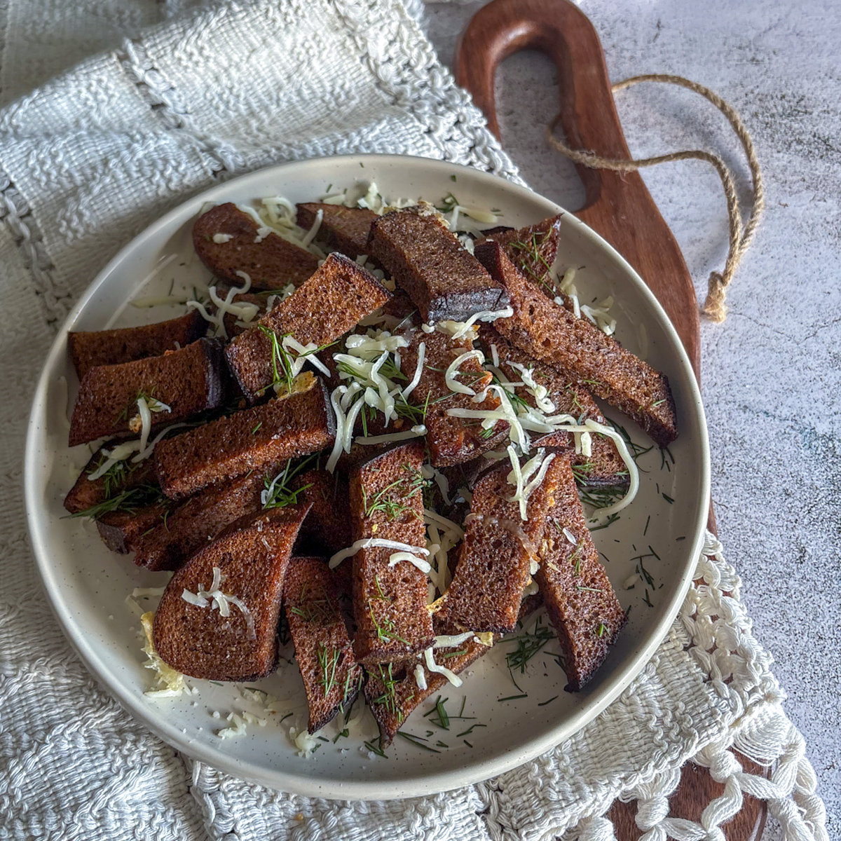 Traditional garlic rye bread snacks for beer served on a rustic plate with