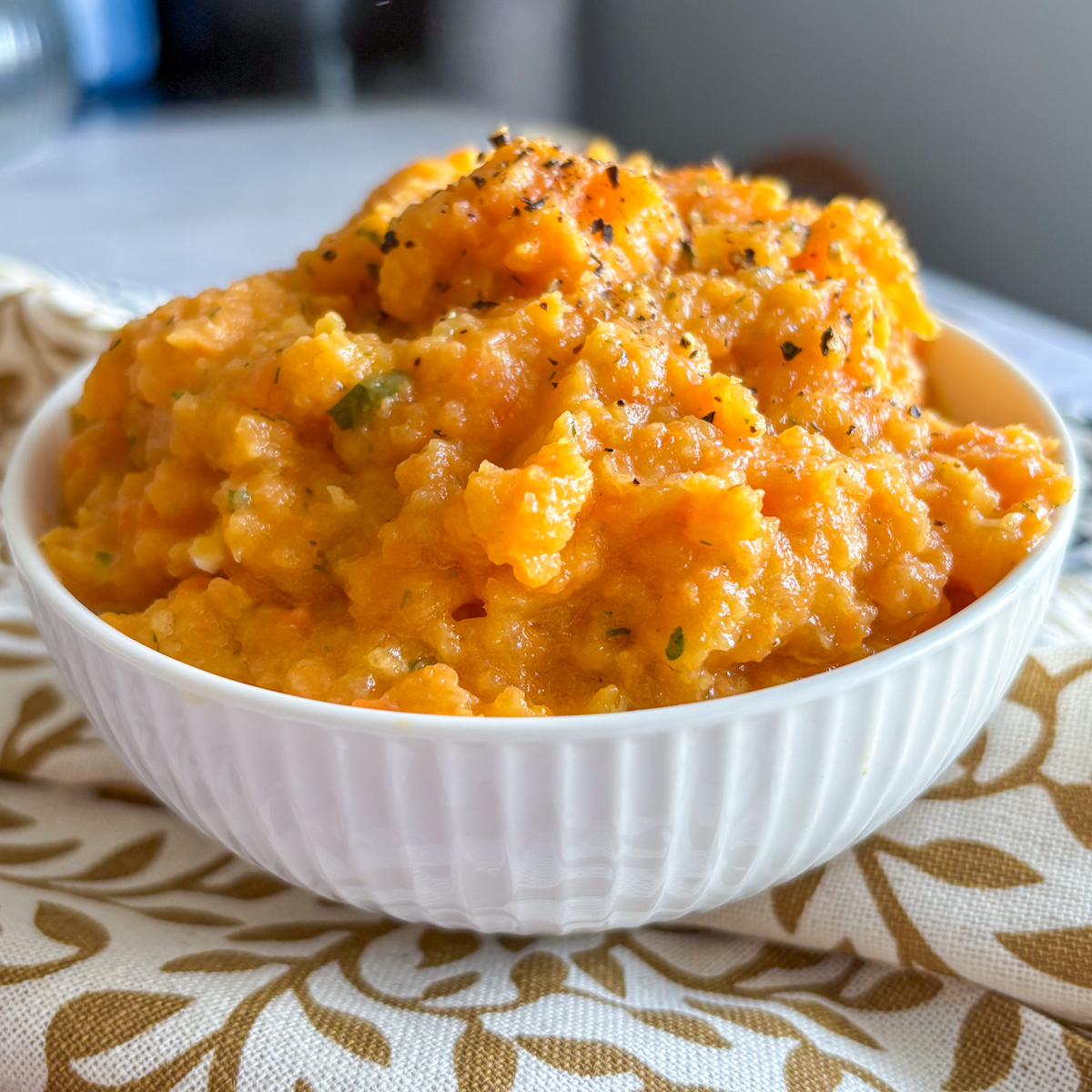 Close up of silky carrot and turnip mash in a white bowl
