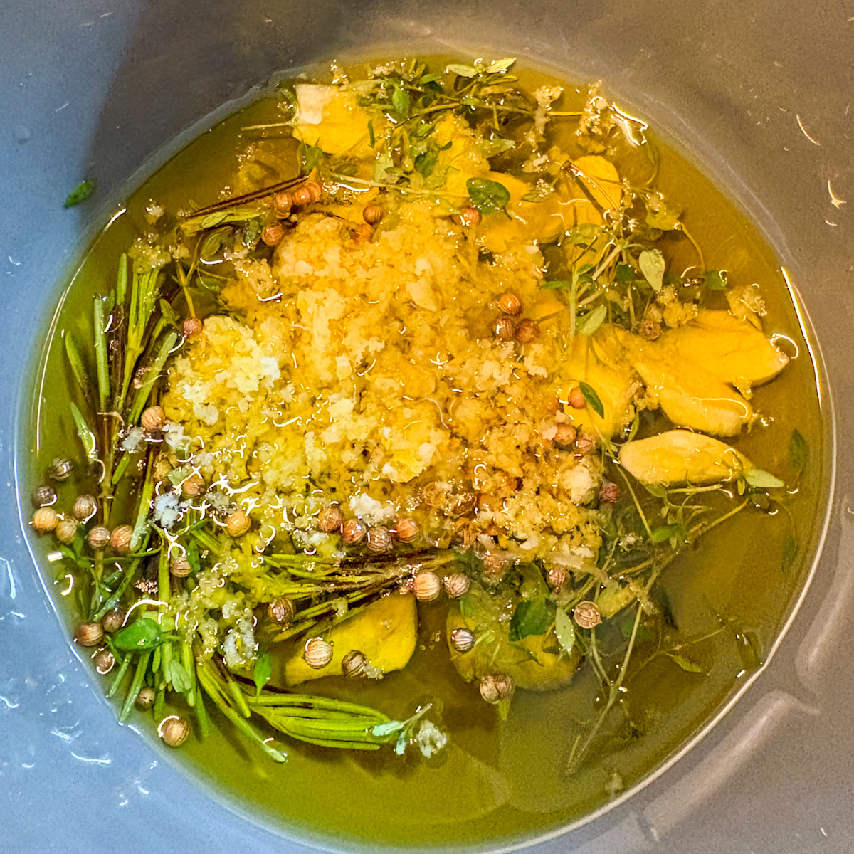 Olive oil infused with garlic, rosemary, thyme, coriander and cumin seeds for marinated olives