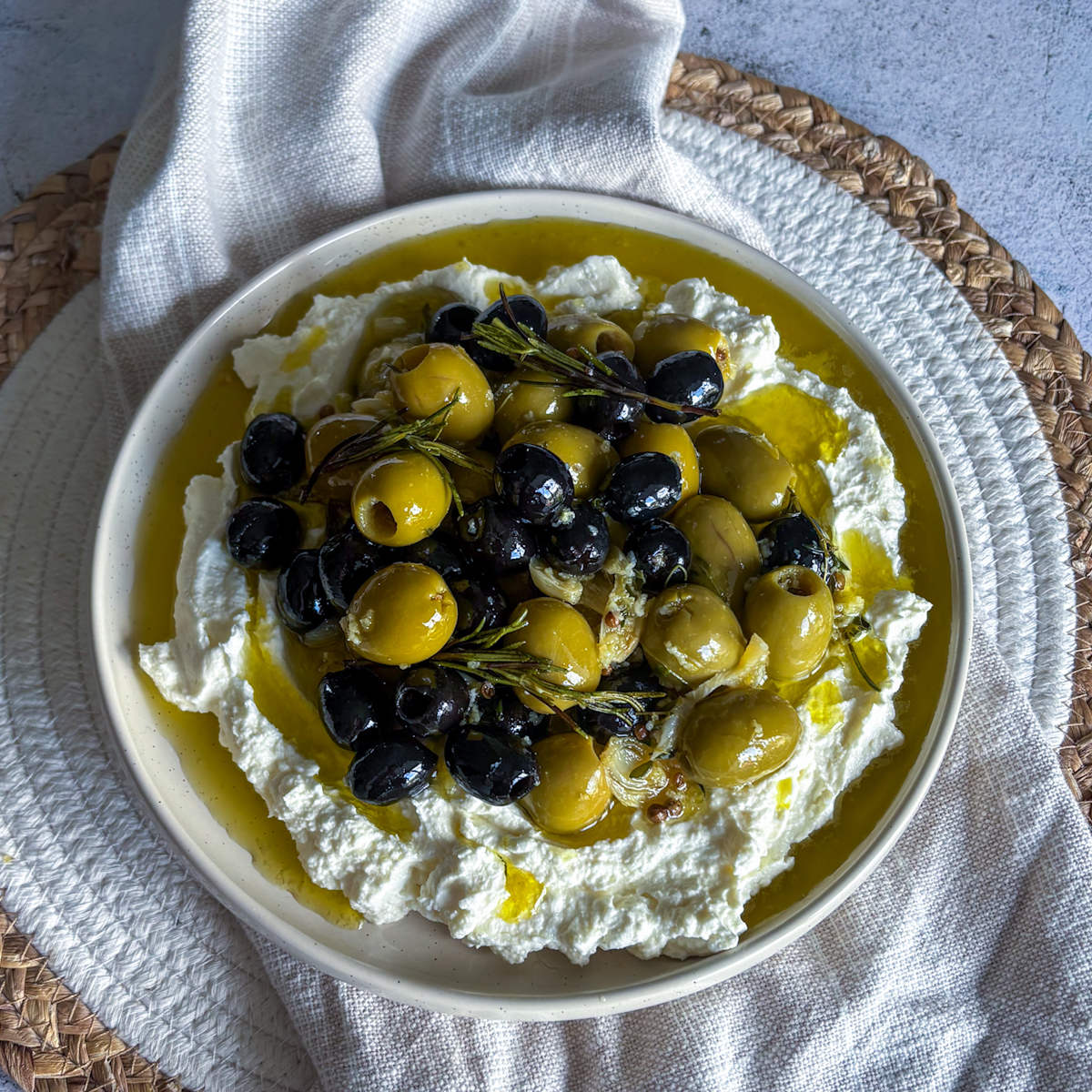  Mediterranean appetiser with warm marinated olives spooned over silky whipped feta