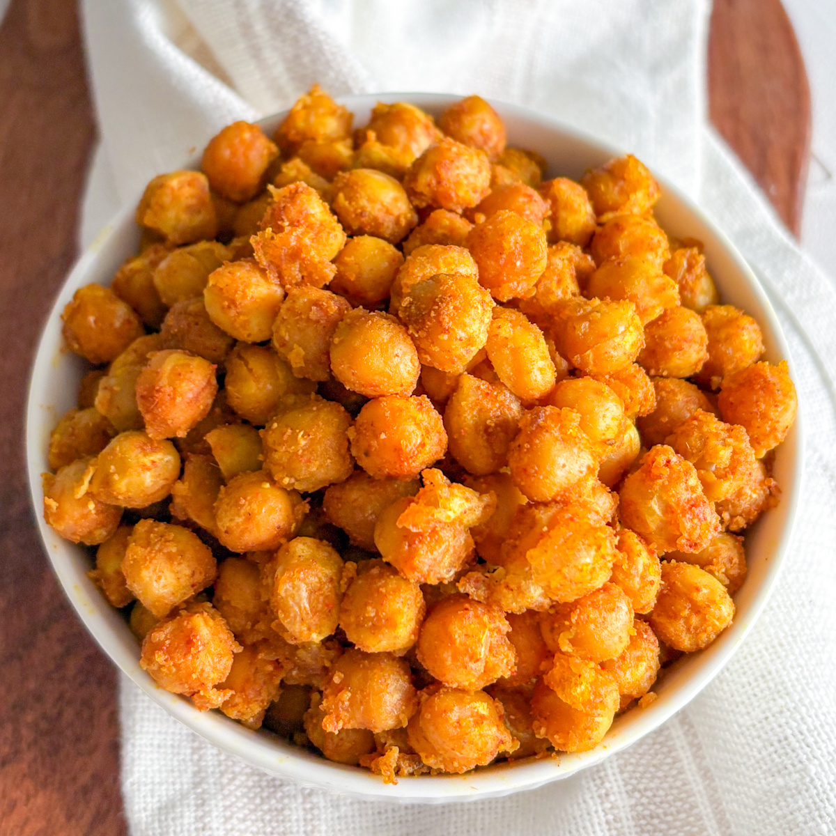 Top-down view of a completed easy crispy chickpea snack recipe, resting on a white cloth and wooden board.