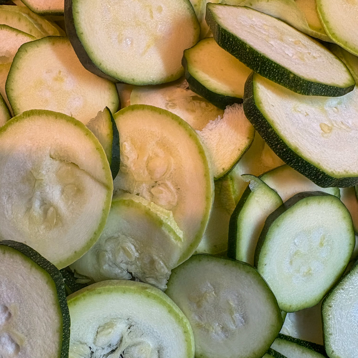 Thinly sliced raw courgettes salted and resting to remove bitterness before braising