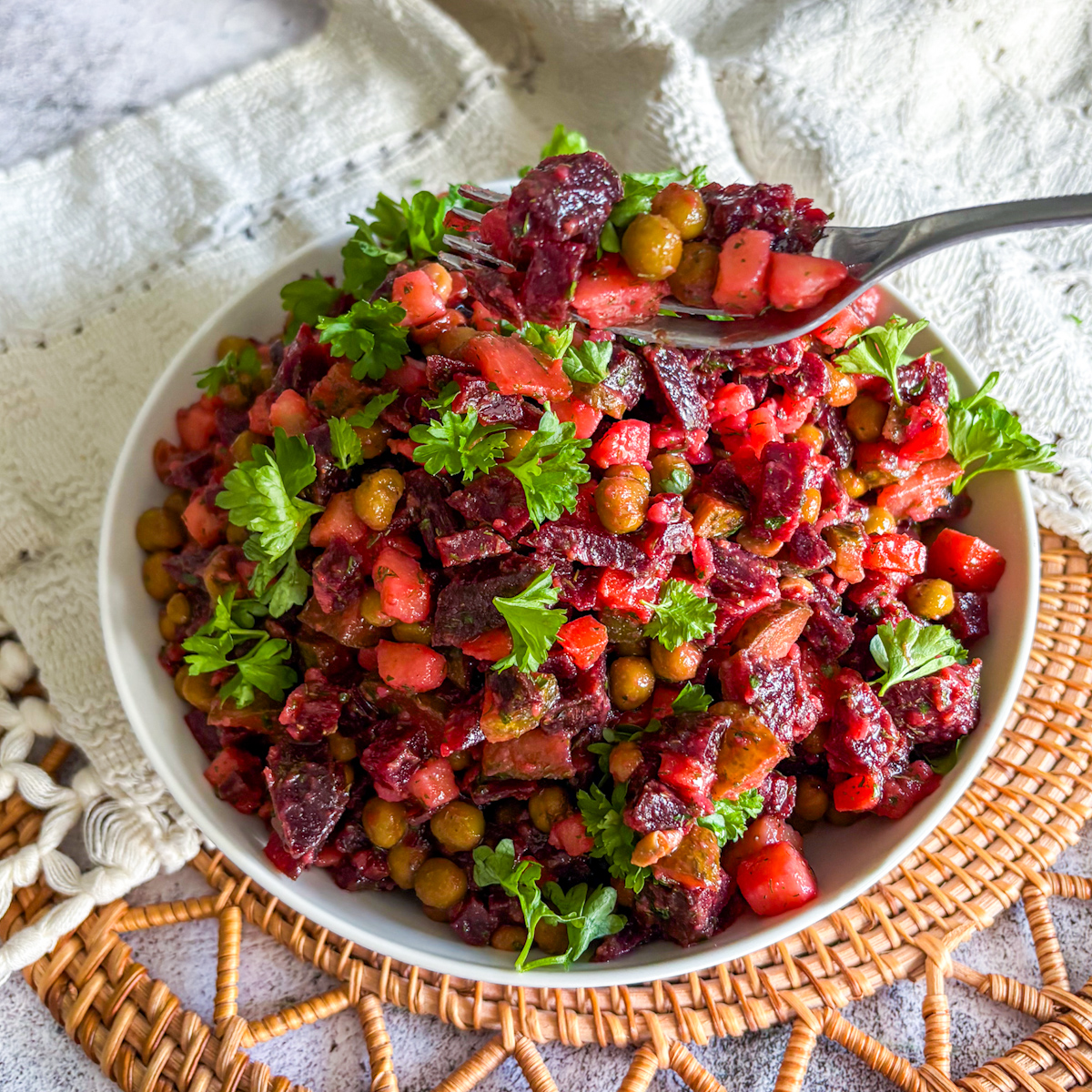 Fork lifting a bite of classic vinaigrette salad recipe with beetroot, peas and parsley