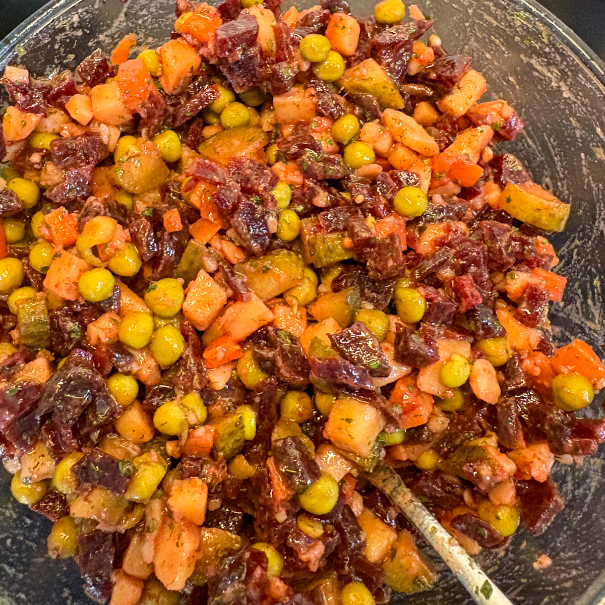 Finished vinaigrette salad mixed in a bowl with dressing and peas
