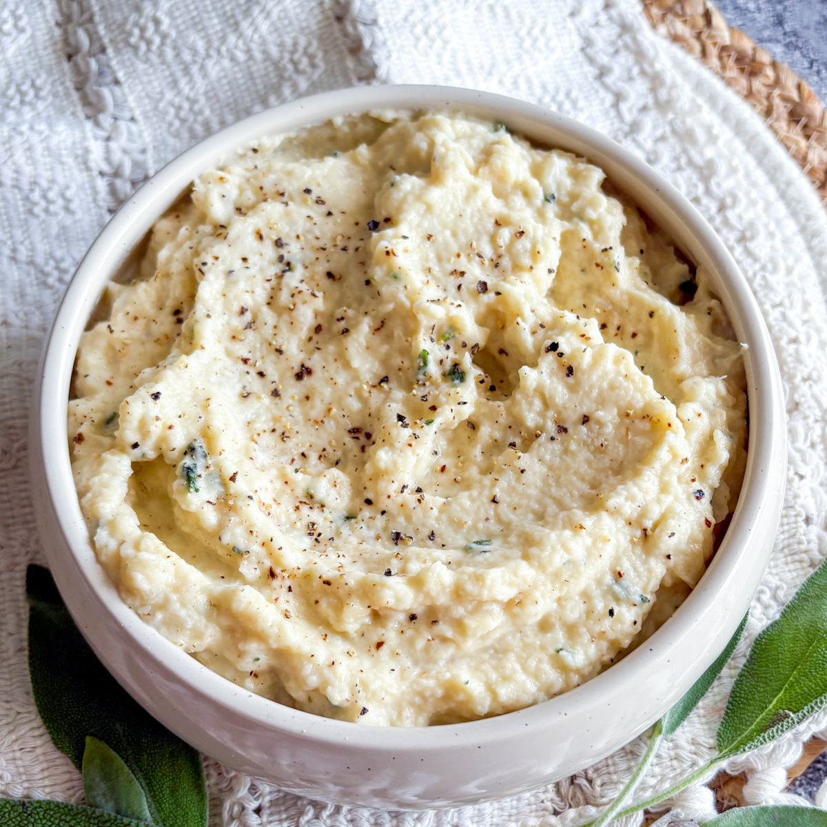 Easy celeriac purée garnished with fresh sage leaves