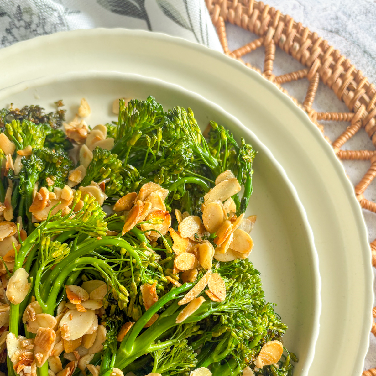 Charred broccolini with golden flaked almonds and minced garlic in close-up