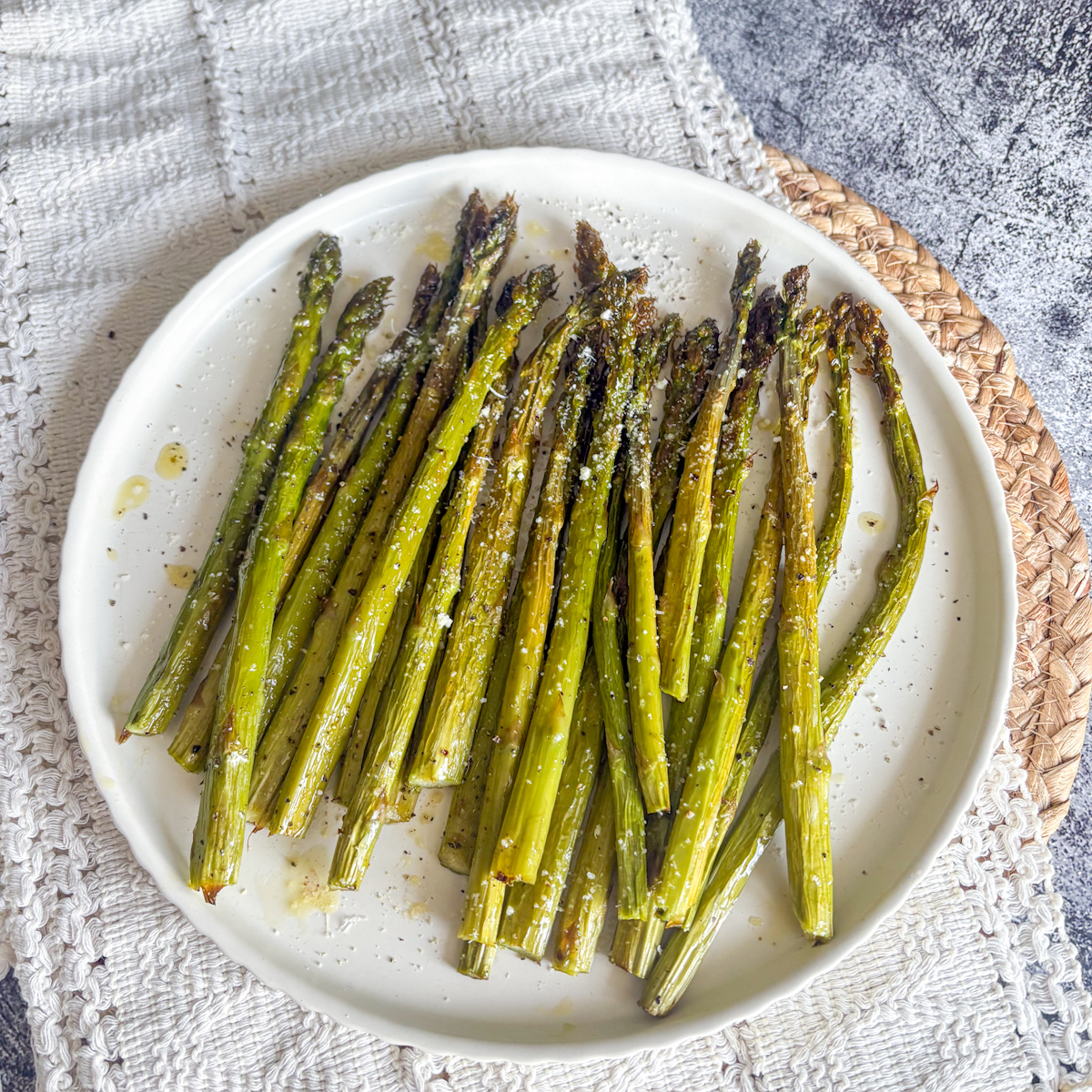 Roasted asparagus spears with charred tips and a dusting of parmesan, photographed from above.