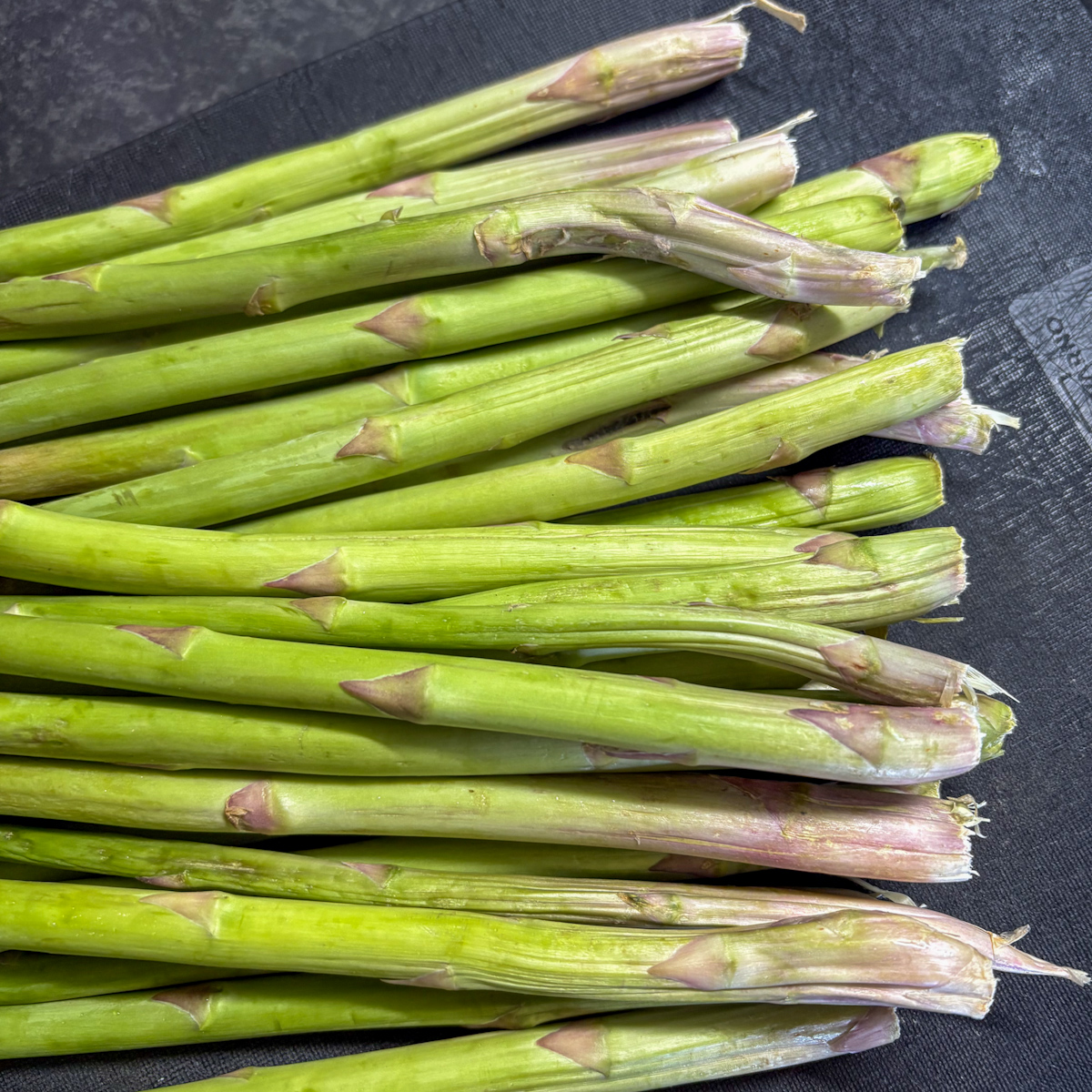 Trimming asparagus stems showing where the woody ends were cut before roasting in the oven.