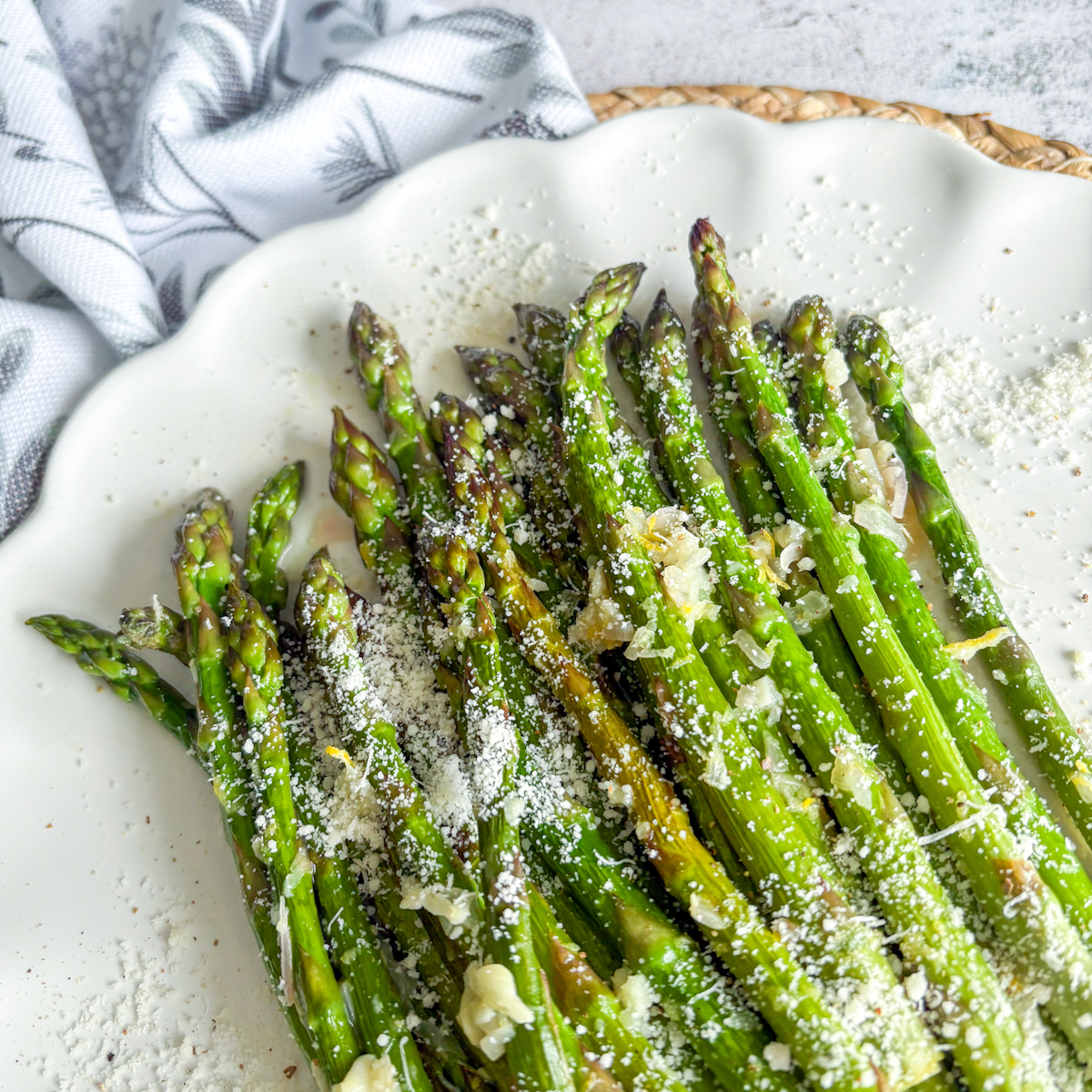 Close-up of pan-steamed asparagus with shaved Parmesan, lemon zest and shallot garlic butter.