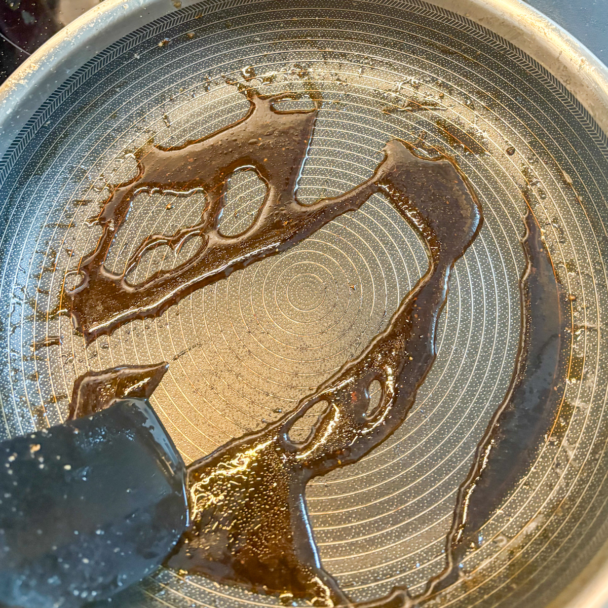 Thick honey balsamic glaze in a pan for caramelised pear salad dressing