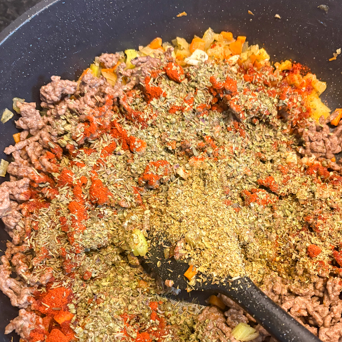 Seasoning mix added to browned beef mince and vegetables for dirty rice