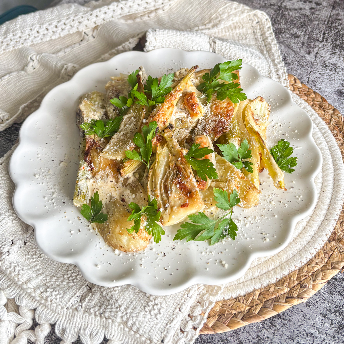 Baked fennel wedges in cream sauce topped with fresh parsley