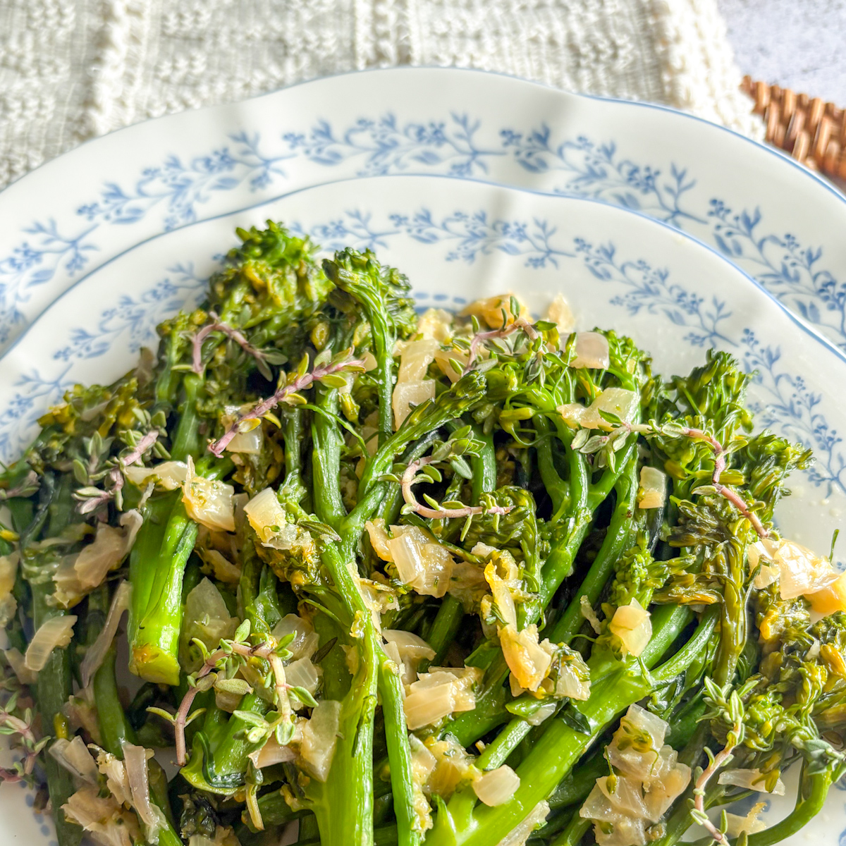 Pan-steamed broccolini with garlic and shallot served on a decorative dinner plate