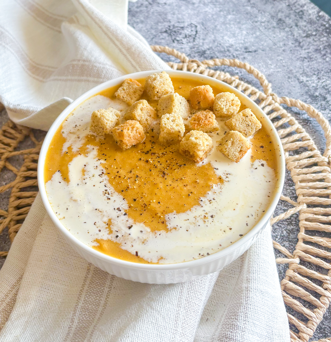 Easy roasted root vegetable soup recipe topped with croutons, cream and freshly cracked black pepper