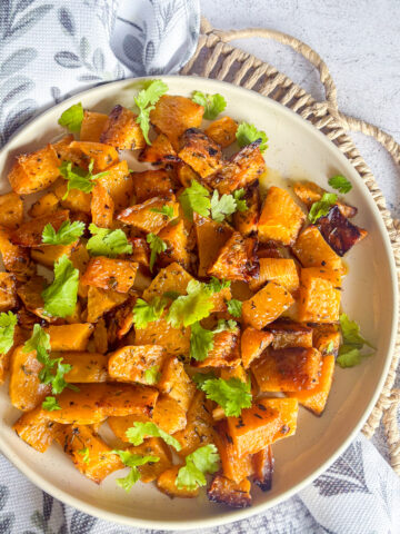 Easy roasted turnips garnished with fresh parsley served on a cream plate